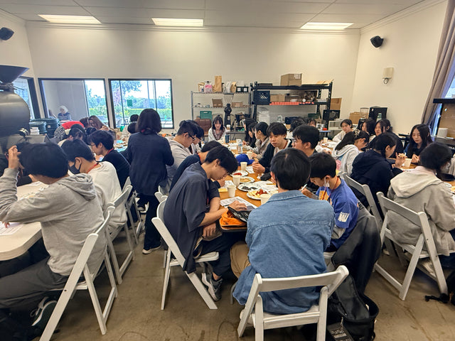 a group of multiple students and people in lucky's roastery, doing a sensory tasting and experience